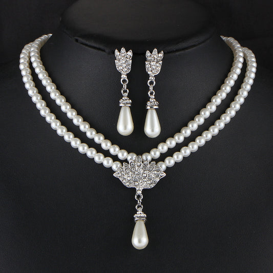 Bridal pearl necklace set with double-strand white pearls, crystal accents, and drop pearl pendant; matching earrings.