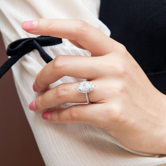 Ring with large oval gemstone center and diamond halo on pavé band