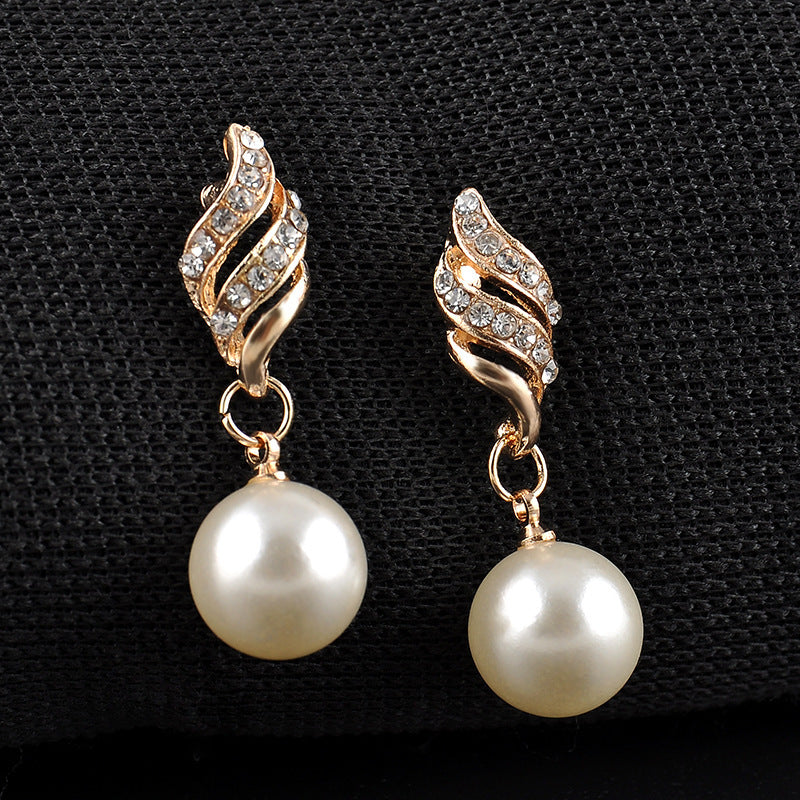 Pair of gold-tone spiral earrings with pavé crystal accents and hanging white pearl drops