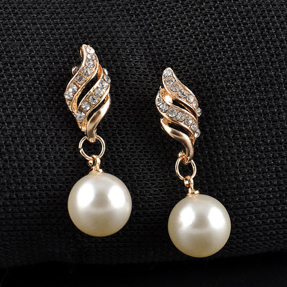Pair of gold-tone spiral earrings with pavé crystal accents and hanging white pearl drops