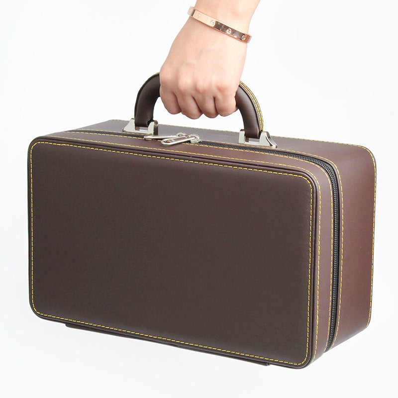 edenista jewelry storage box; brown leather case with yellow stitching and dual zippers, handheld.