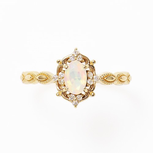 Gold-tone opal ring with ornate vintage setting and small accent stones