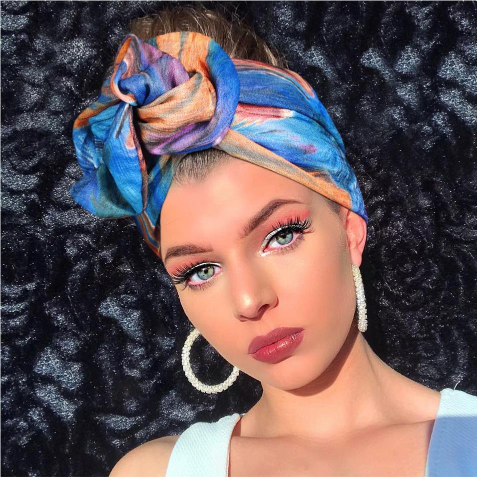 Hairband silk scarf headwrap in vibrant multicolor print, tied in a knot on top.