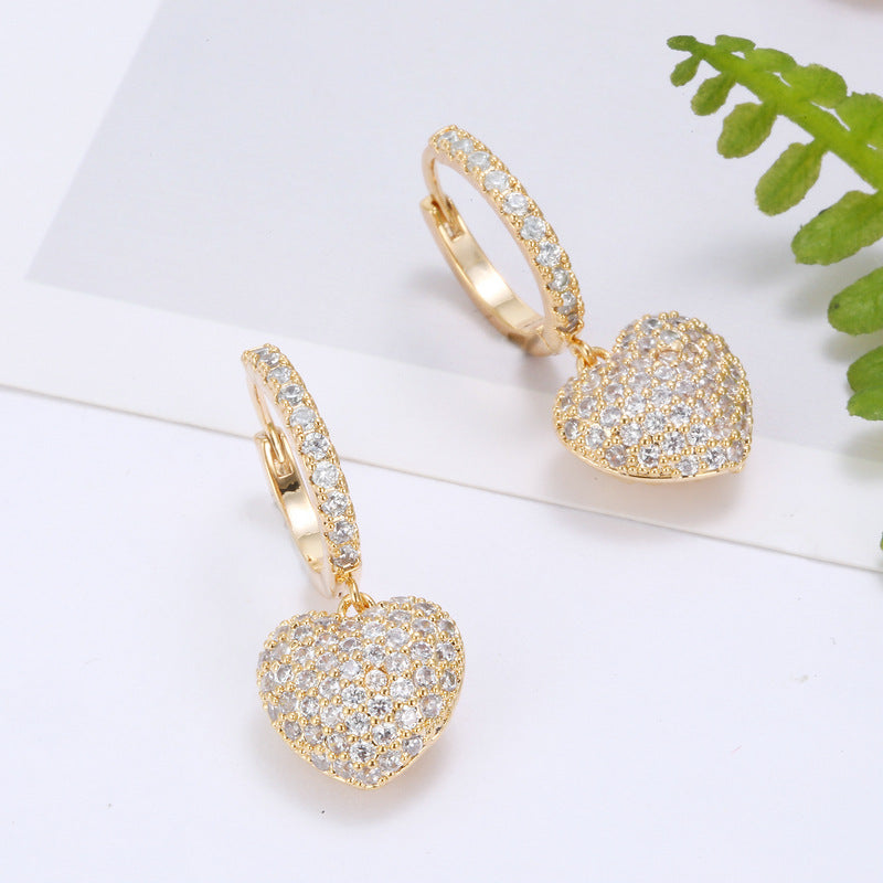 Gold-tone hoop earrings with heart-shaped pavé crystal pendants; pair.