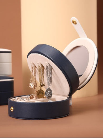 Portable jewelry box by edenista, navy exterior with cream interior, open to display necklaces and bracelets.