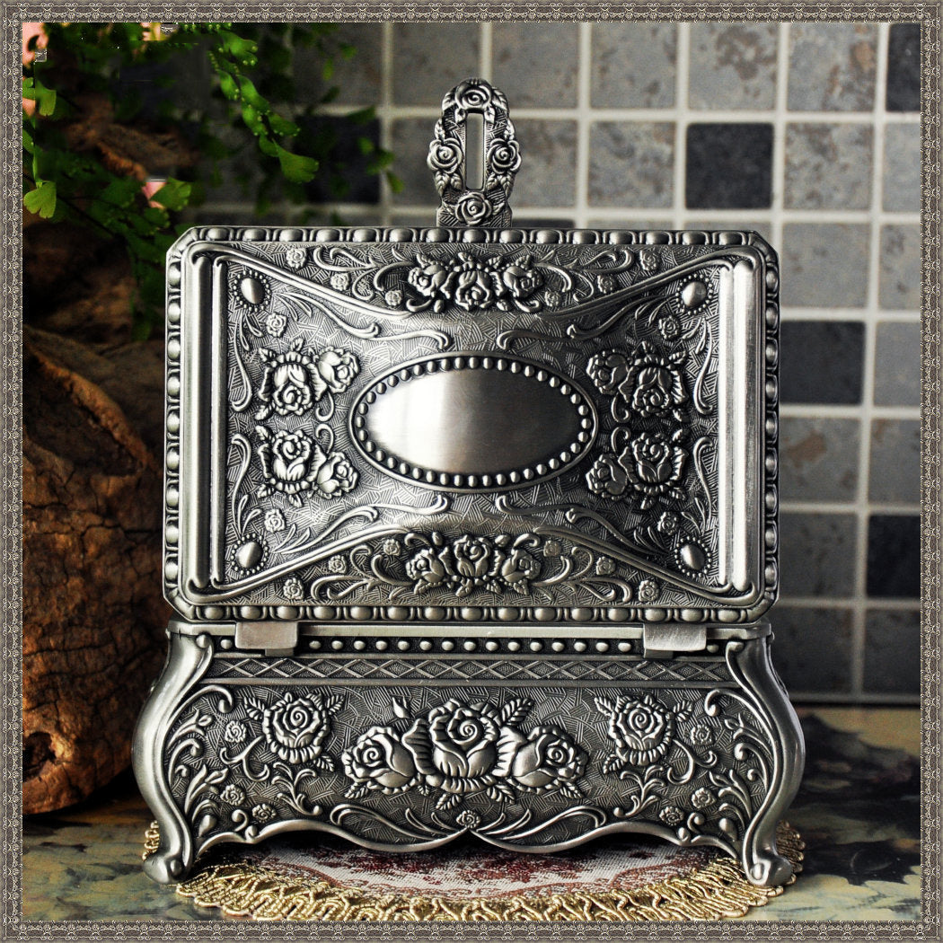 Vintage jewelry box by Edenista; ornate silver-toned metal with rose floral engravings and hinged lid.