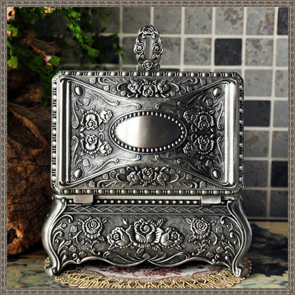 Vintage jewelry box by Edenista; ornate silver-toned metal with rose floral engravings and hinged lid.