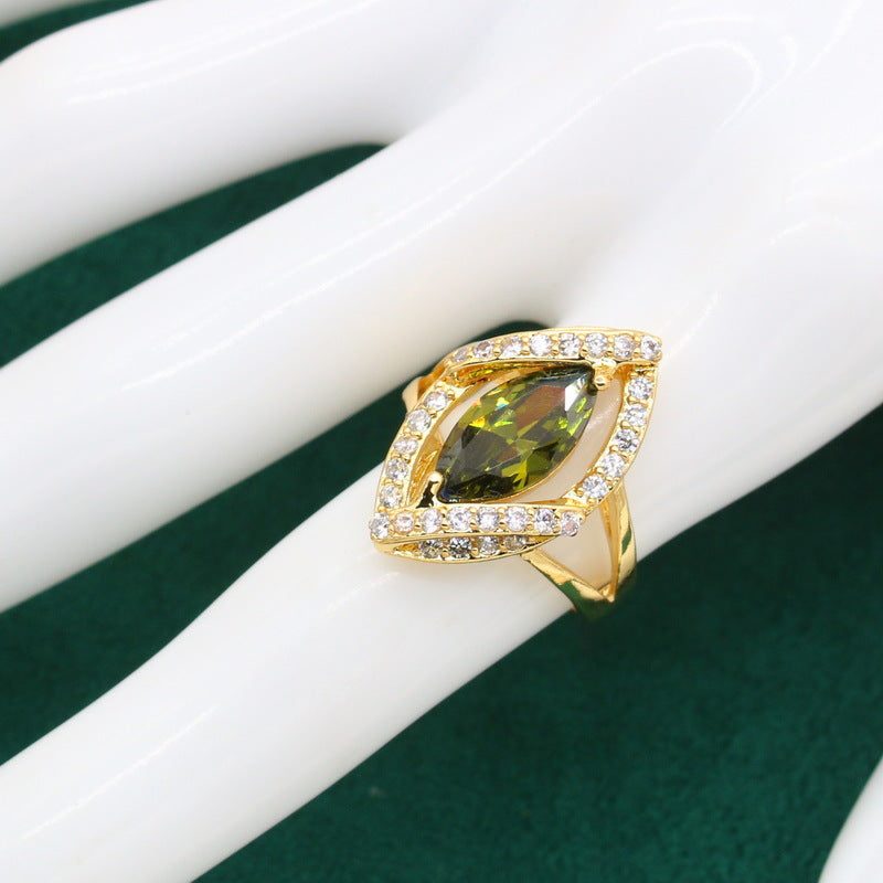 Gold-tone ring with a marquise-cut green zircon center stone surrounded by pavé diamonds