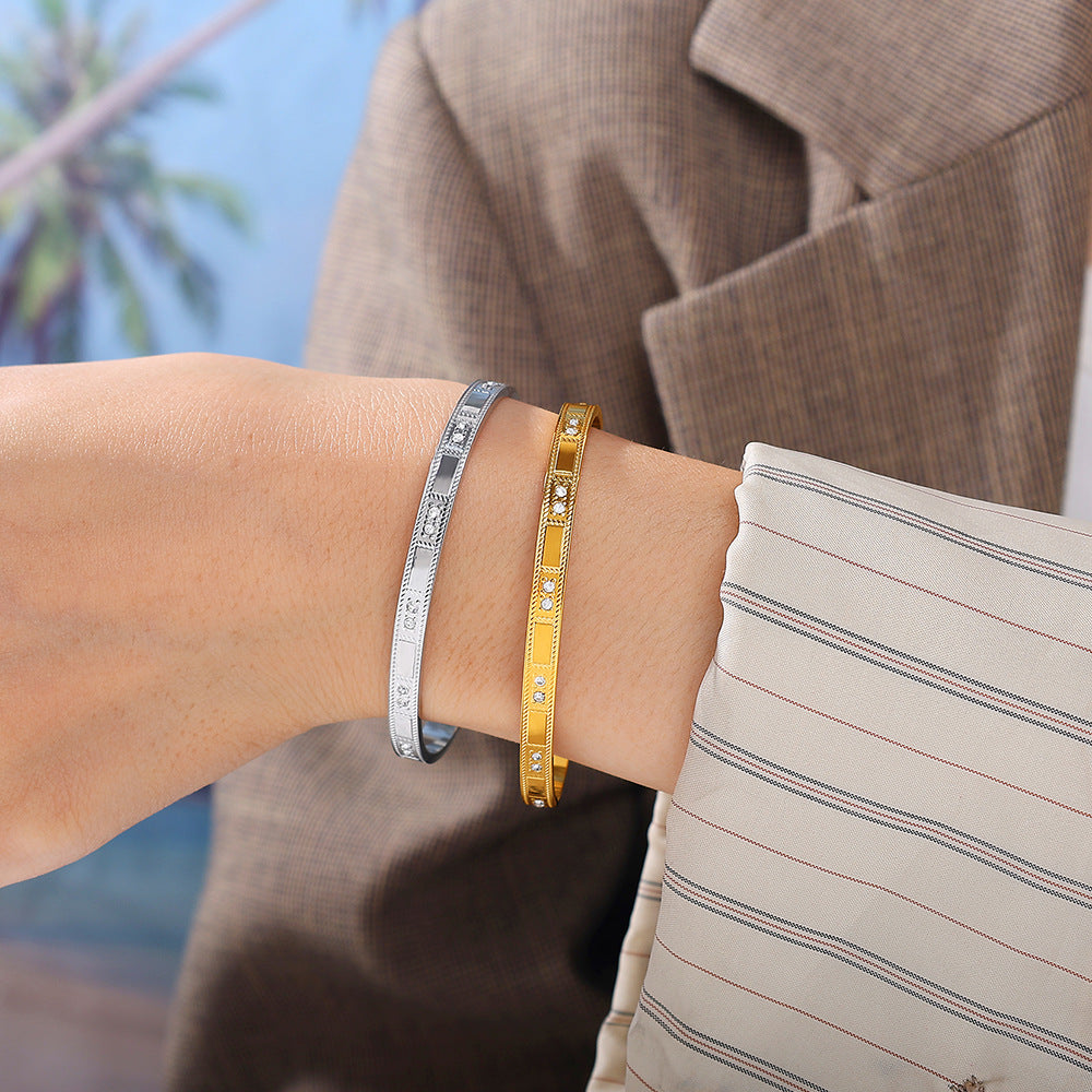 Buckle alloy open-end bracelets (two shown), silver-tone and gold-tone with crystal accents.