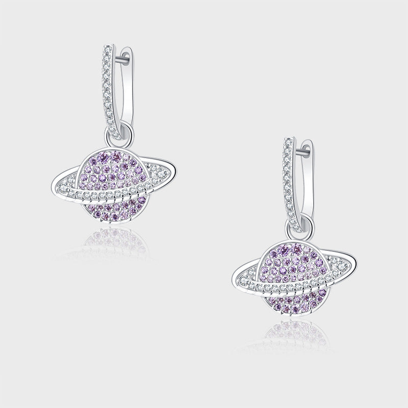 Pair of silver earrings with purple gemstones on a light gray background