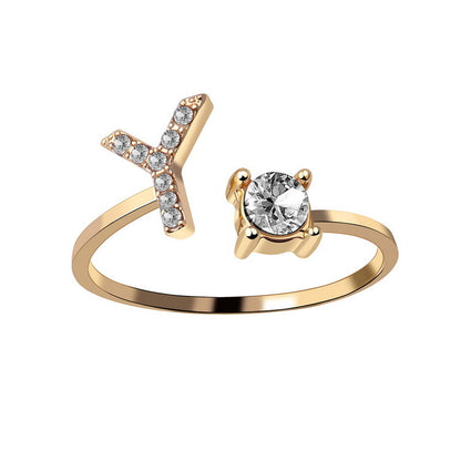 Adjustable gold-tone ring with X-shaped crystal accents and a solitaire gem
