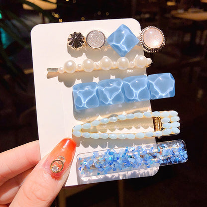 Girls' pearl and blue hair clip set with pearl strand, faceted blue squares, and a mosaic blue clip