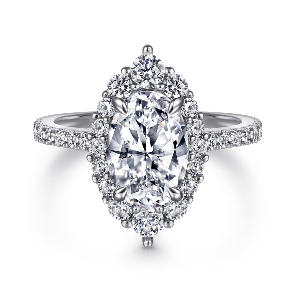 Oval-cut gemstone halo ring with pave diamonds on a silver band