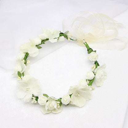 Bridal flower wreath headpiece with white artificial roses and blossoms on green stems, sheer ribbon bow