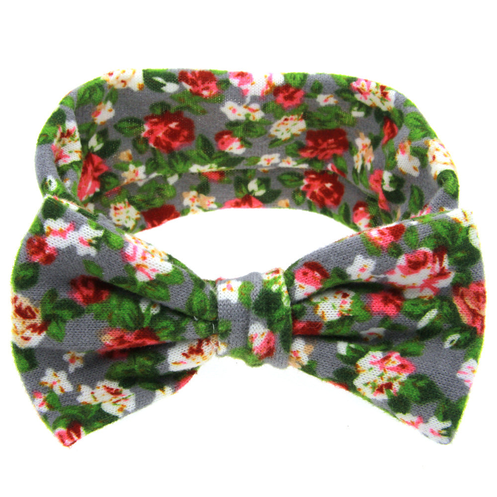 Floral children's hairband with bow; grey fabric featuring red, white, pink flowers and green leaves.