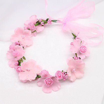 Artificial pink floral bridal hair wreath featuring multiple pink roses and blossoms with a sheer pink bow.