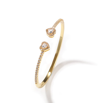 Gold open-circle bracelet with twin heart-shaped diamond ends and pave diamonds along the band, by cj