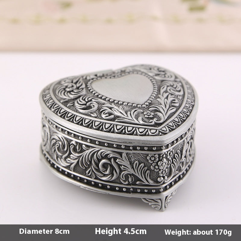 Jewelry storage box by Edenista; heart-shaped, silver-toned metal with intricate floral engravings.