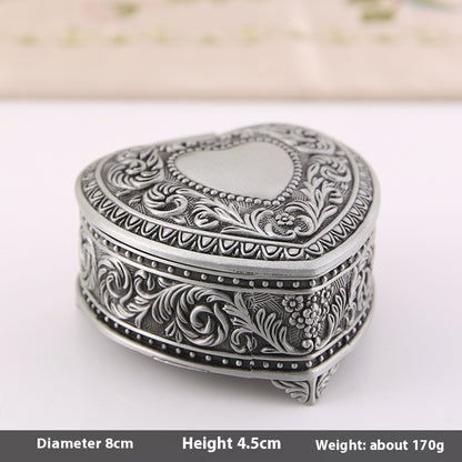 Jewelry storage box by Edenista; heart-shaped, silver-toned metal with intricate floral engravings.