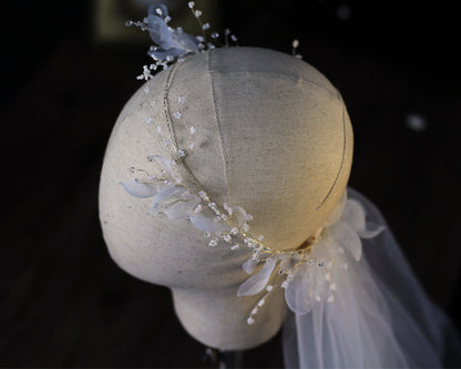 Bridal wreath veil headpiece with silver beaded floral accents and sheer veil on a mannequin bust