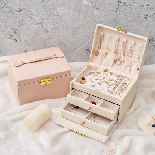 Three-layer drawer jewelry box by edenista, cream with gold hardware; two boxes shown, pink beside it.