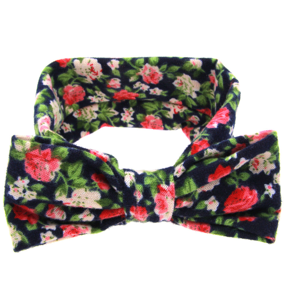 Floral children's hairband with navy background, pink florals, and bow detail by CJ