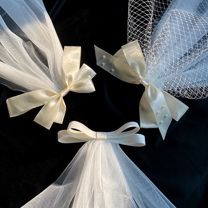Bow veil set: ivory satin bows with white tulle veils (3 pcs) on black background