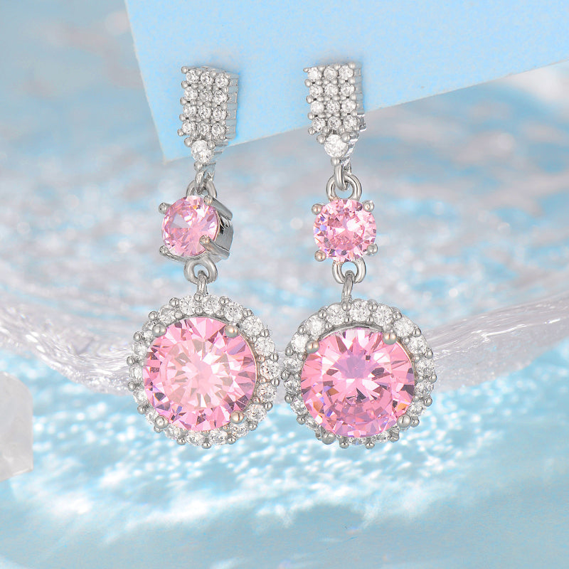 Pair of CJ silver-tone drop earrings featuring pink round stones surrounded by crystal halos