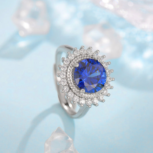 Ring by cj with blue gemstone halo, silver band, and diamond accents