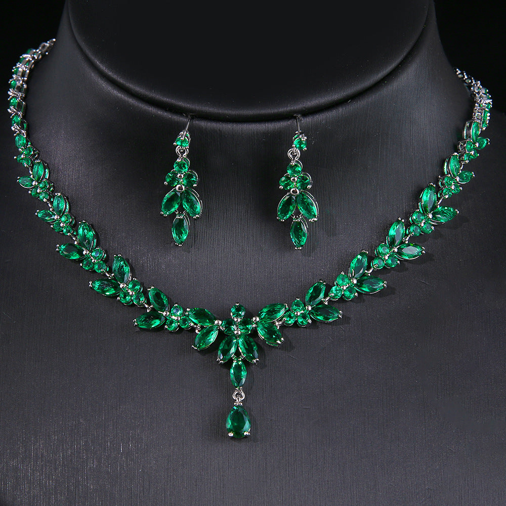 Two-piece necklace and earrings set with emerald-green zircon in white gold finish, CJ brand.