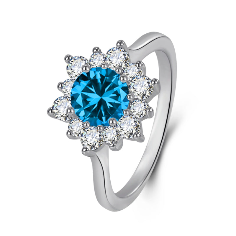 Ring with blue center gemstone encircled by a halo of white diamonds in a silver setting