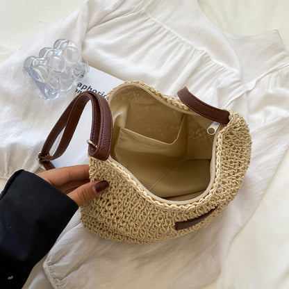 Niche Design Vacation Straw Tote Bag with natural straw body and brown leather handles.