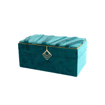 Jewelry storage box in teal velvet with a gold-trimmed, quilted lid and hanging gold pendant charm.