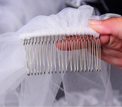 Metal hair comb held over a white veil with a blurred background