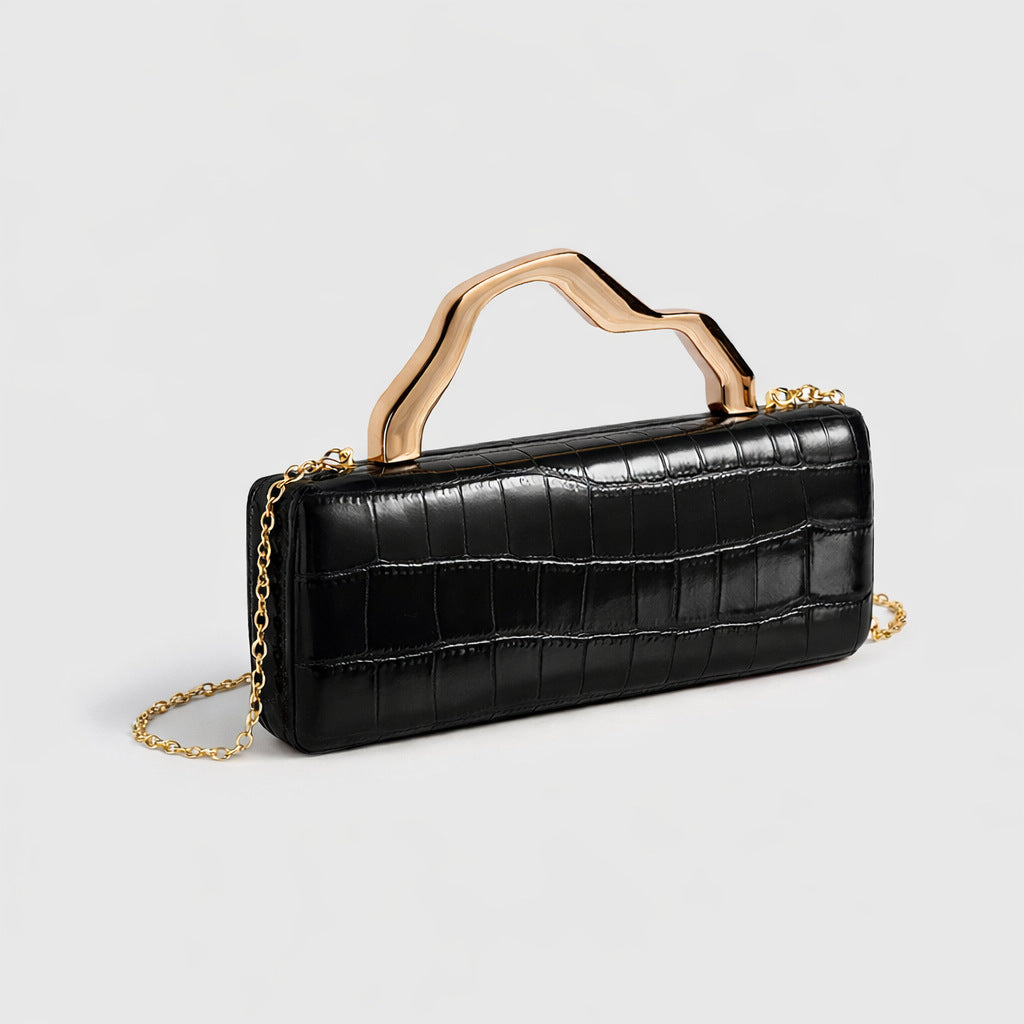 Evening clutch with crocodile-pattern black PU, gilded sculpted handle and gold chain strap.