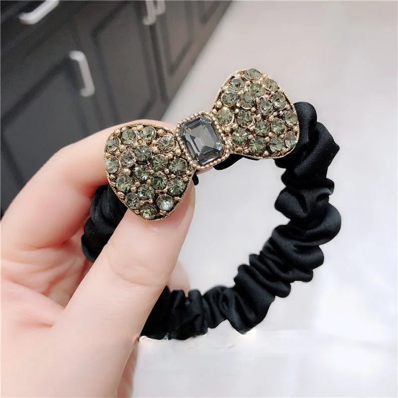 Rhinestone bow scrunchie Edenista; black elastic band with green stones and a central gray gem