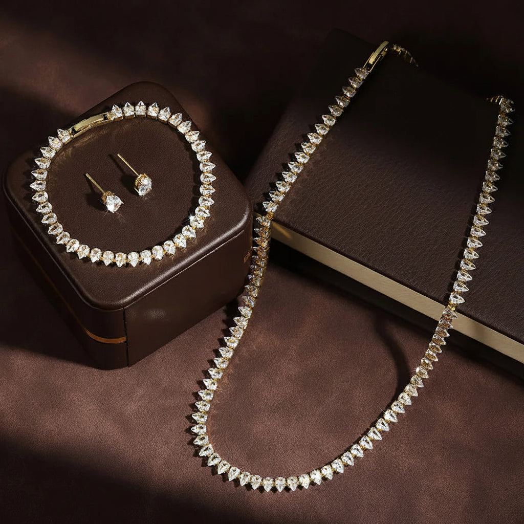 Jewelry set with necklace, bracelet, and earrings on a brown surface with 'ZAKOL' branding.