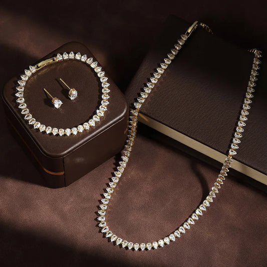Jewelry set with necklace, bracelet, and earrings on a brown surface with 'ZAKOL' branding.