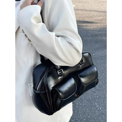 Women's black leather bowling bag with multiple front pockets and a shoulder strap.