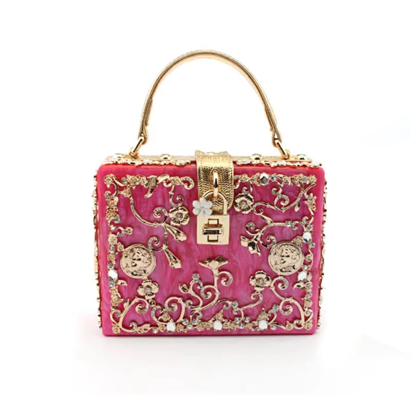 Pink acrylic evening clutch with gold-tone rhinestone floral embroidery and top handle.