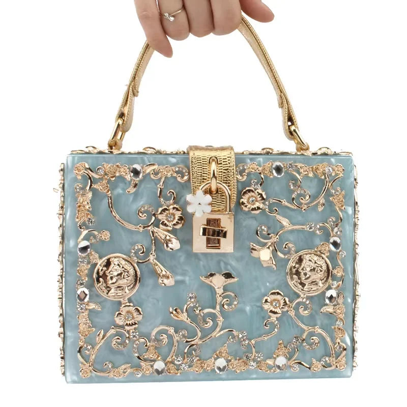 Edenista acrylic evening bag with pale blue body, gold floral filigree and rhinestones, with a gold lock clasp
