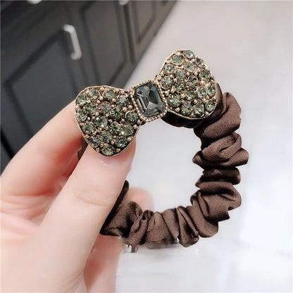 Rhinestone bow scrunchie in brown satin with green stones and center gem, elastic hair tie