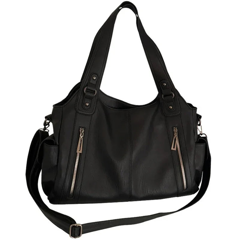 Women's black leather tote bag by Edenista with top handles, detachable crossbody strap, and multiple zip pockets.