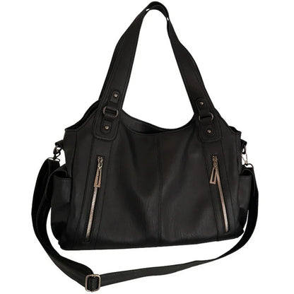 Women's black leather tote bag by Edenista with top handles, detachable crossbody strap, and multiple zip pockets.