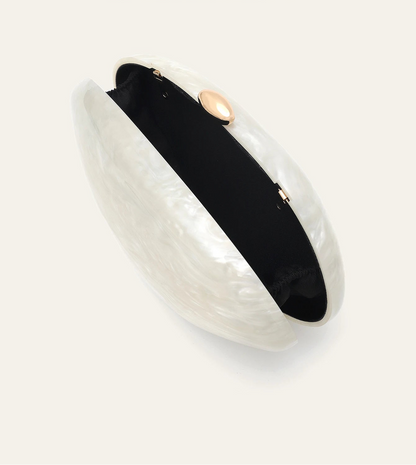 Edenista shell-shaped acrylic clutch, pearl-white with black interior and gold-tone round clasp.