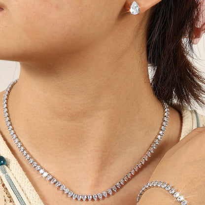Model neck close-up wearing silver pear-cut CZ water drop tennis necklace with matching teardrop stud earring