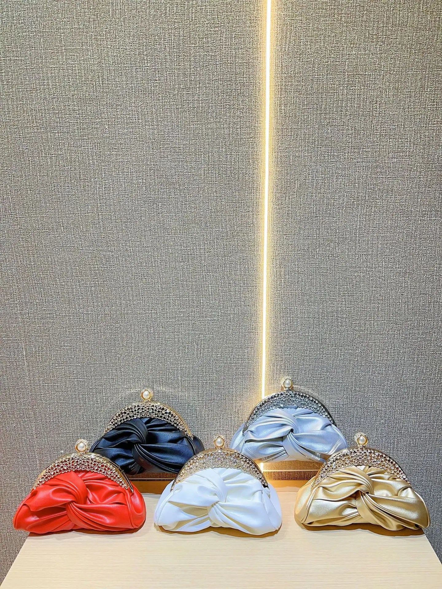 Satin prom clutches with crystal-embellished frames in red, black, light blue, white, and gold