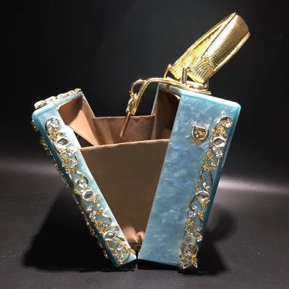 Acrylic evening clutch with turquoise panels, gold rhinestone trim, and brown interior.