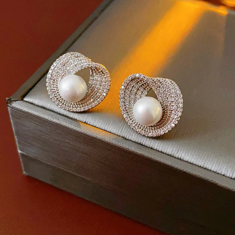 Pair of Edenista Zircon round pearl earrings; silver-tone pave crystal hoops with central white pearls