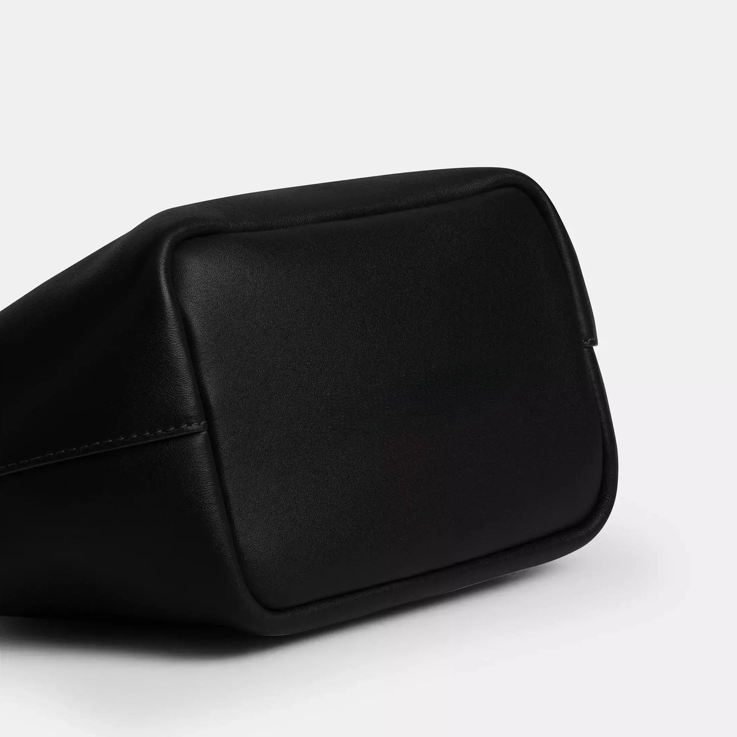 Edenista black microfibre leather kiss-lock top-handle clutch bag close-up corner